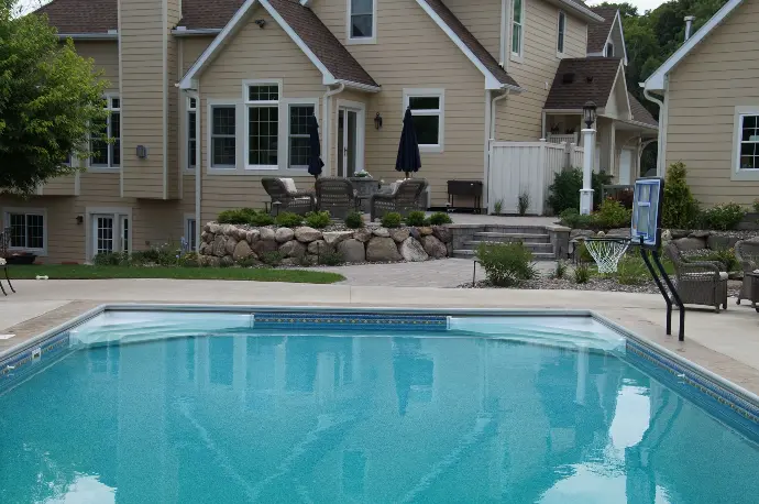 A beautifully designed custom pool featuring surrounding natural stone pavers, blending luxury with function in a serene outdoor space.