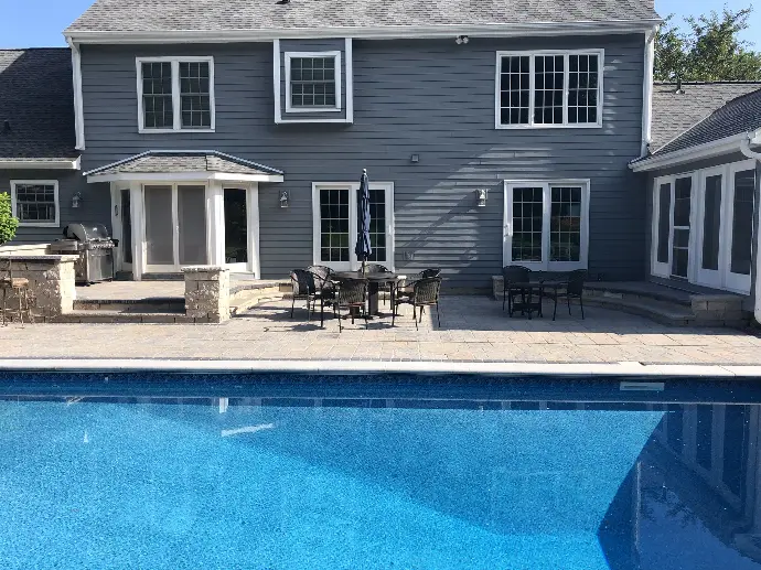 A beautifully designed custom pool featuring surrounding natural stone pavers, blending luxury with function in a serene outdoor space.