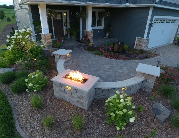 A custom-built stone fireplace surrounded by built-in seating, creating a cozy focal point for outdoor gatherings.