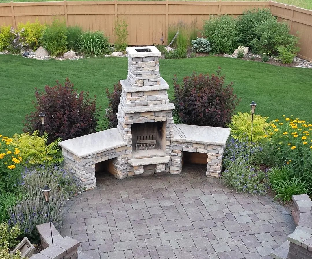 A brick outdoor fireplace with a chimney, creating a traditional and elegant centerpiece for the patio.