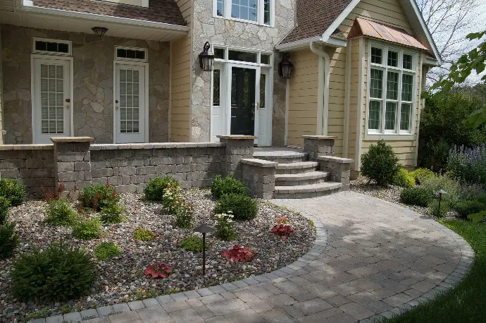 A wide natural stone paver walkway leading to the front door, creating a welcoming entrance.