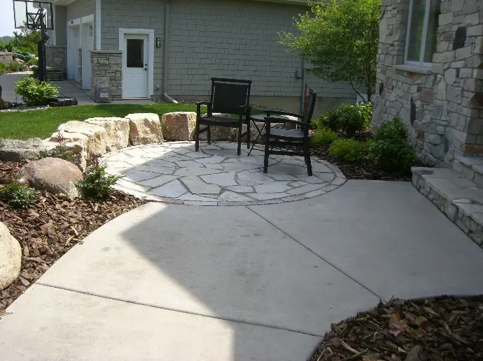 A modern natural stone patio design featuring sleek outdoor furniture and a minimalist layout.