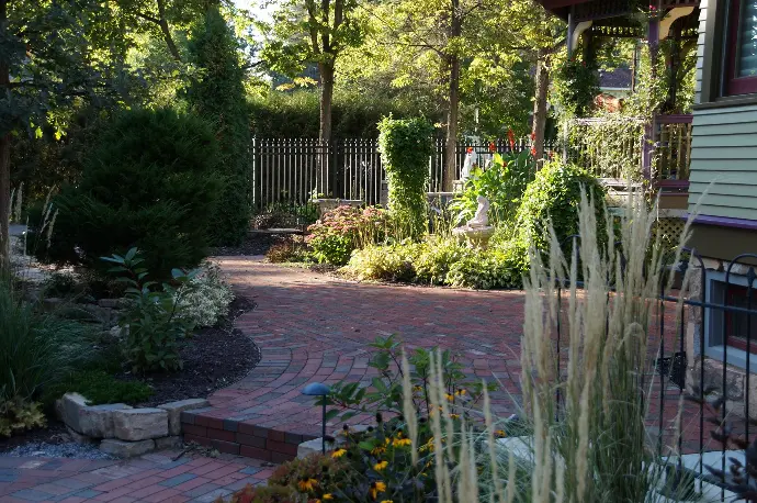 A circular stone paver patio nestled within a vibrant flower garden, offering a perfect retreat for enjoying nature.