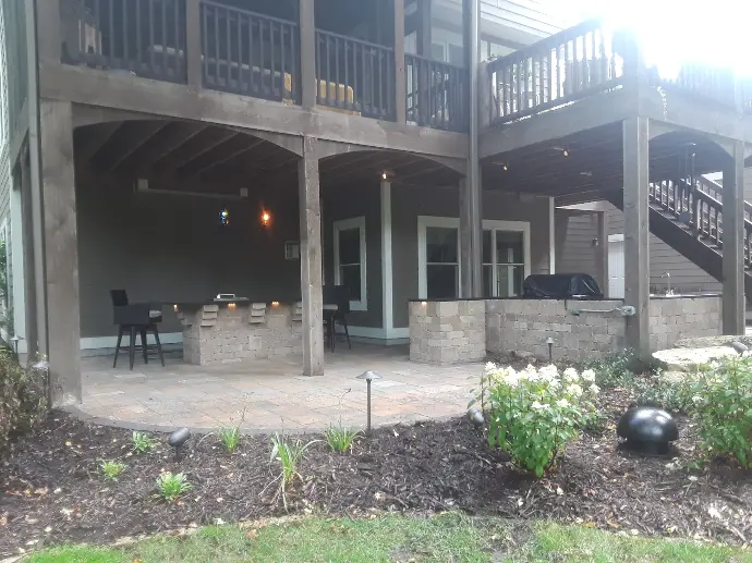 A functional outdoor kitchen area with bar seating and a built-in grill, perfect for entertaining guests.