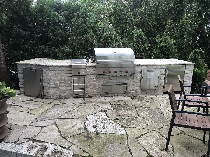 A sleek, modern outdoor kitchen featuring stainless steel appliances and a clean, minimalist design.