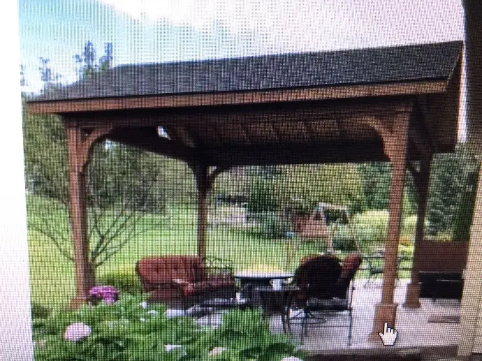 A custom wooden pergola providing shade over a dining set, making for a stylish and functional outdoor dining area.