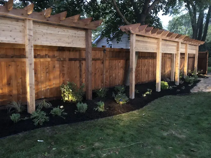 A custom garden trellis surrounded by blooming flowers and a stone pathway, creating a picturesque garden setting.