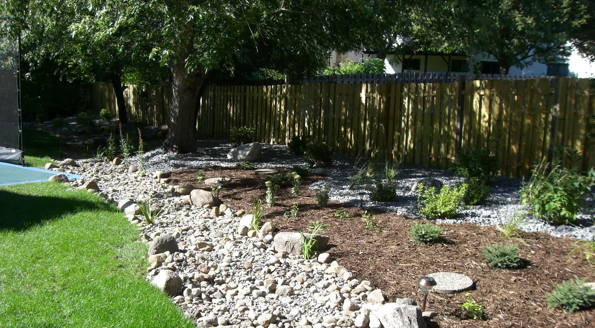 A custom wooden privacy fence with lattice detailing along the top, adding a decorative touch while ensuring privacy.