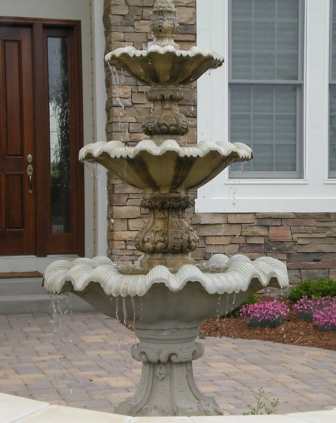  A custom-built stone garden fountain with multi-level basins, creating a tranquil water feature in a modern landscape.