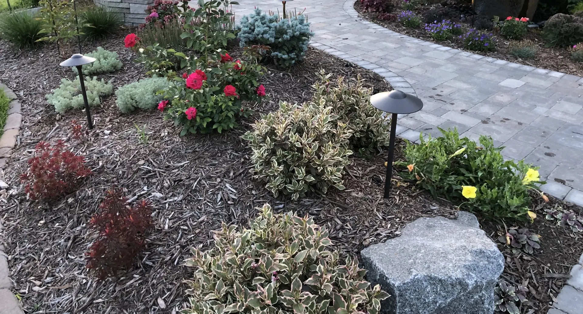 A colorful flower garden bordered by a custom stone retaining wall, blending nature with structure.